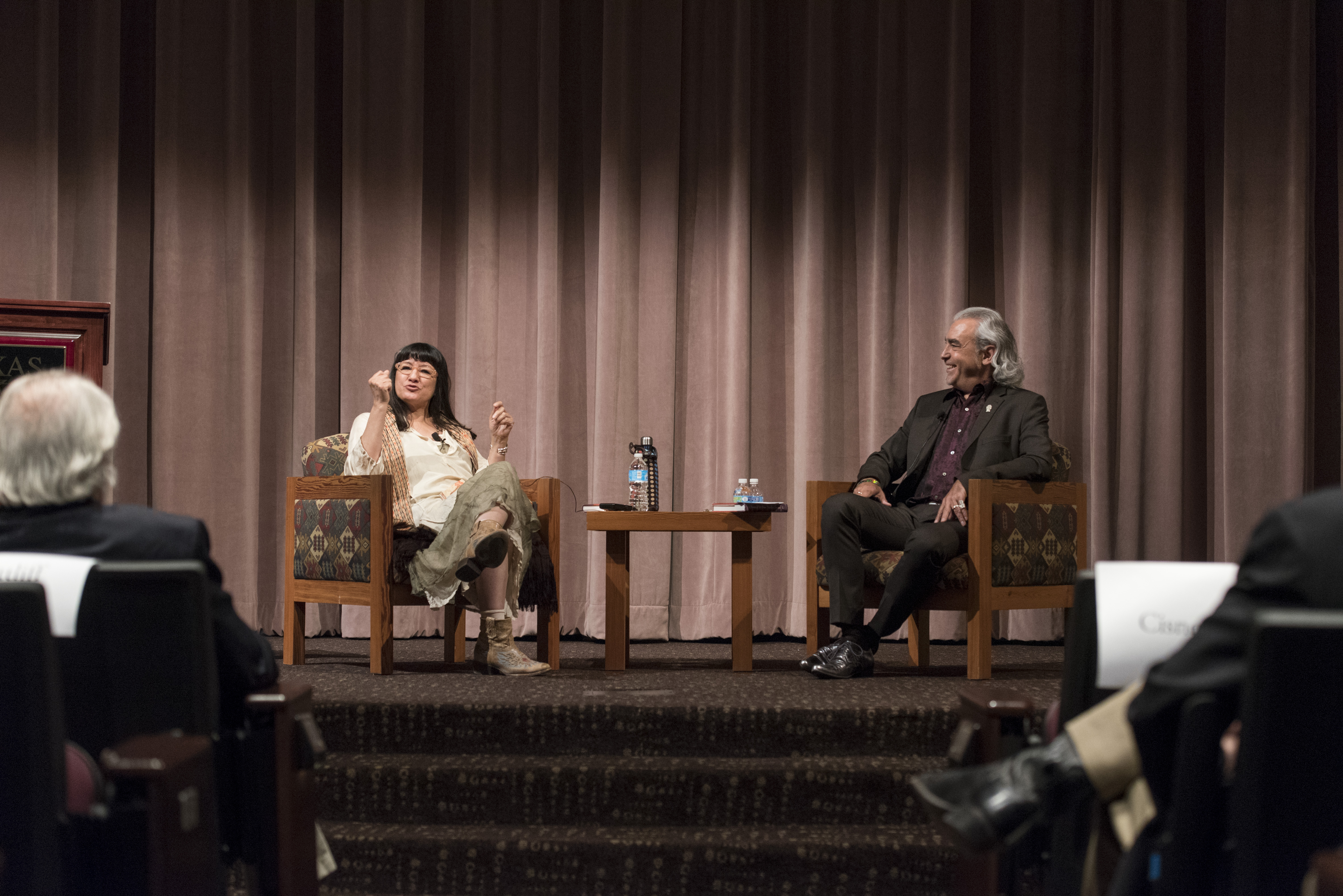 Two speakers on stage gesturing at the audience.